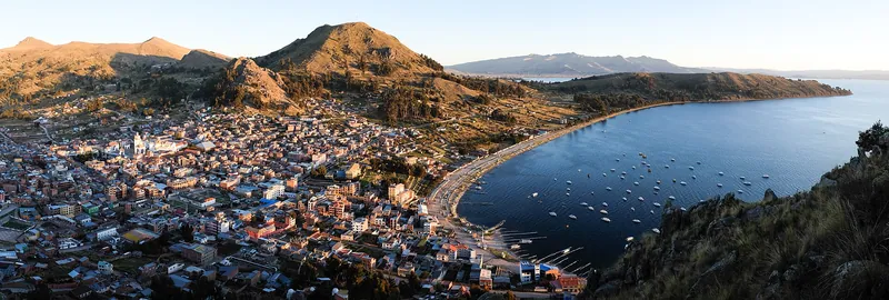 Vista da cidade de Copacabana, na Bolívia, à beira do lago Titicaca, entre montanhas.