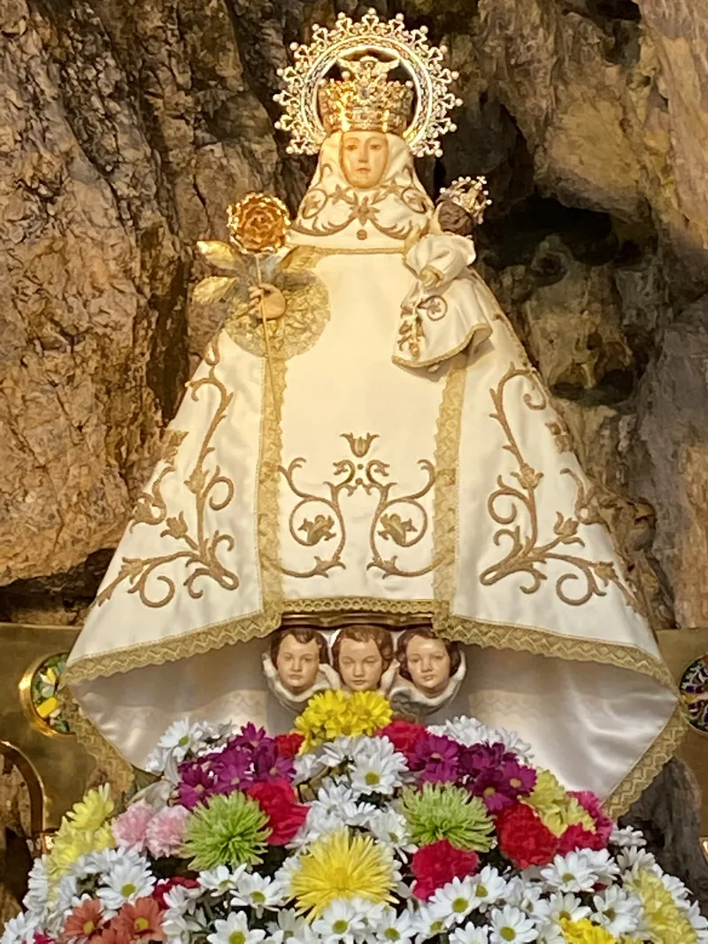 Pequena imagem de Maria com o Menino, com manto branco bordado e coroa.