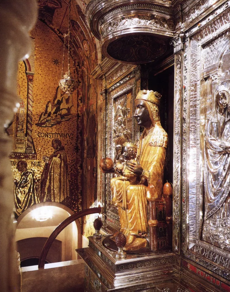 Escultura de Maria de rosto escuro, sentada, com o Menino no colo, ambos com coroas e vestes douradas.